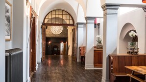 A hallway with wooden flooring, a fireplace, and a bench. - Kurhaus Lenzerheide (Vaz-Obervaz)