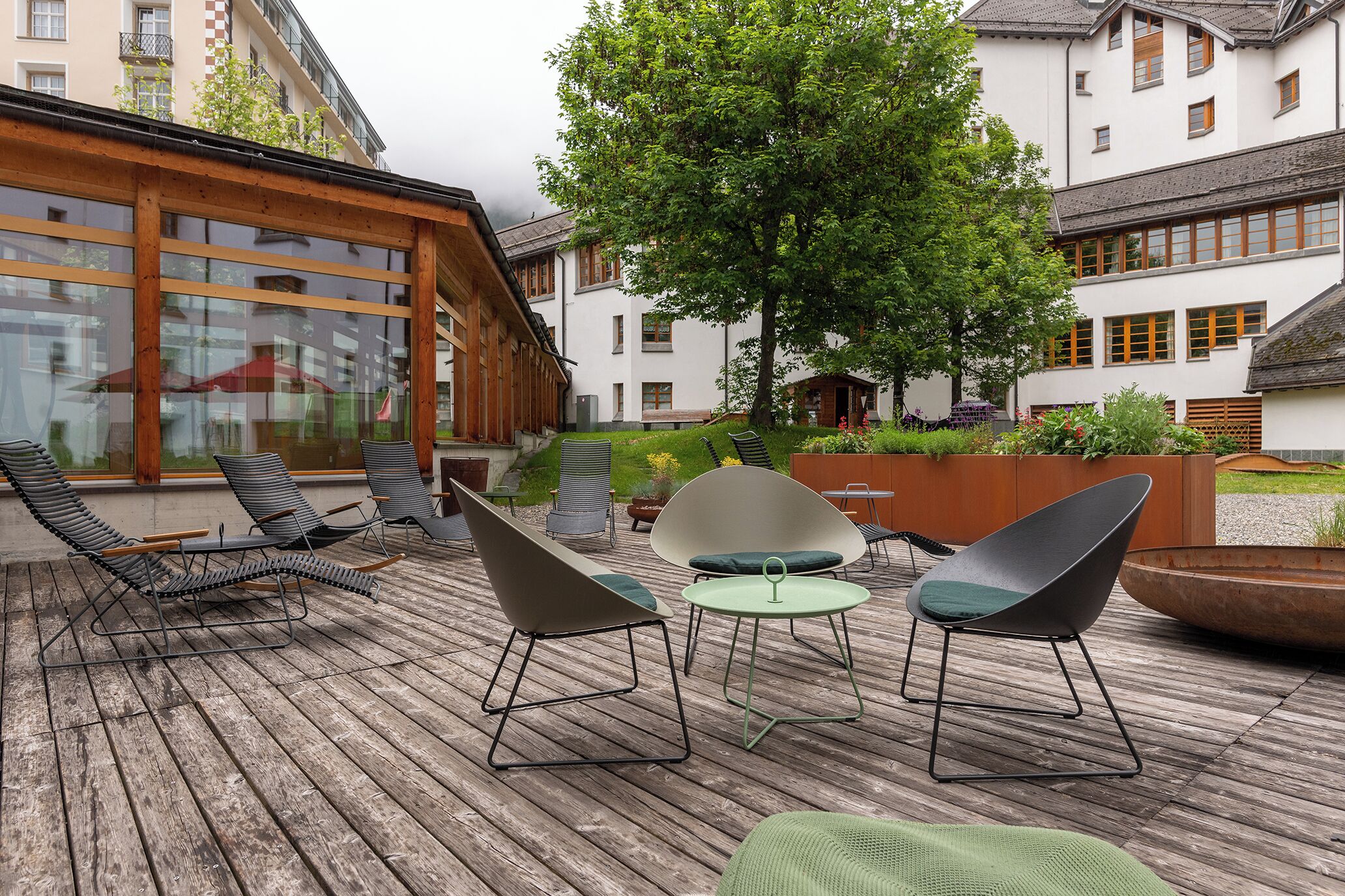 Une terrasse en bois avec un espace salon extérieur, comprenant des chaises longues et une table.