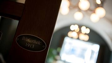 Eine Holzhütte mit einer Tafel, auf der „Bibliothek 1913“ steht.