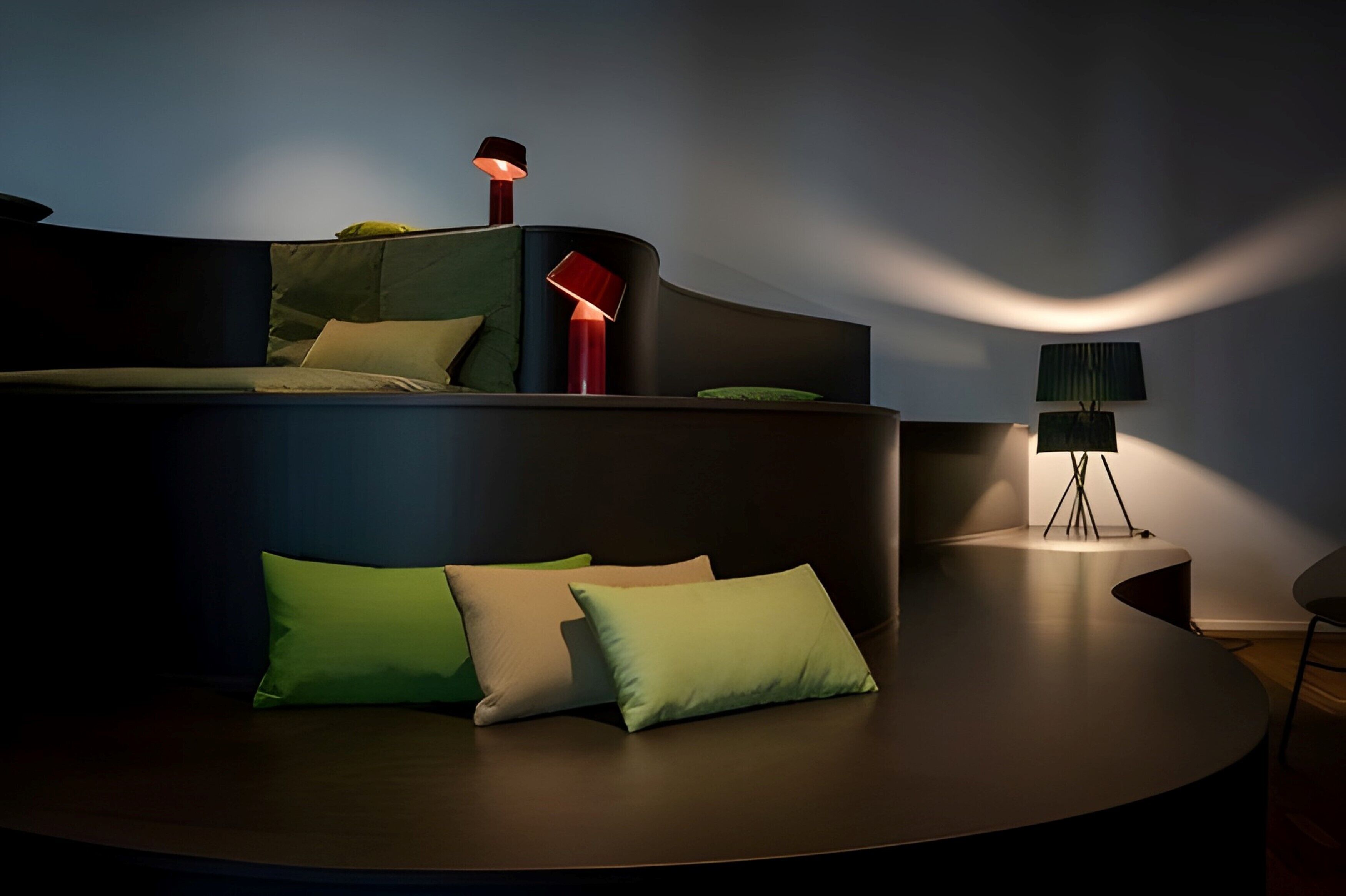 Un sofá moderno y curvo con varios cojines en una habitación con poca luz.