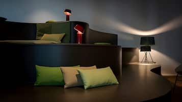 Un sofá moderno y curvo con varios cojines en una habitación con poca luz.