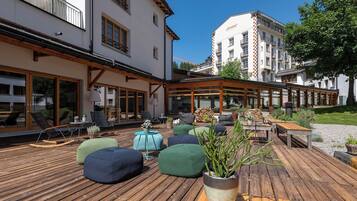 Relax in the shaded outdoor seating area with cushioned benches and chairs.