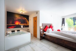 Un baño moderno con bañera, ducha y un espejo grande.