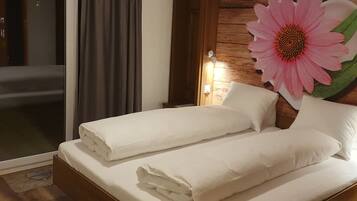 Une chambre d’hôtel avec un lit, une grande décoration florale et une porte coulissante.