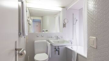 Une salle de bain avec des toilettes, un lavabo et une douche.