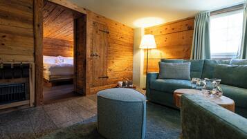 A cozy room with wooden walls, a sofa, a lamp, and a small table with glasses.