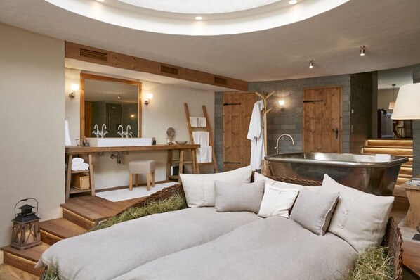 A modern bathroom with a large bathtub, a wooden vanity, and a large mirror. - Maiensässhotel Guarda Val (Vaz-Obervaz)
