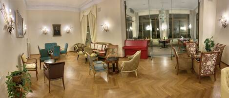 A spacious room with a piano, multiple seating options, and a large window providing a view of the outside.