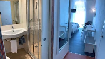 Un baño moderno con cabina de ducha de vidrio, un lavabo y un inodoro.