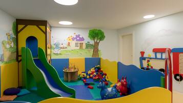 Children can play and learn in this vibrant room with a slide, table, and building blocks.