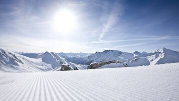 A snowy mountain landscape with a clear sky and distant peaks.