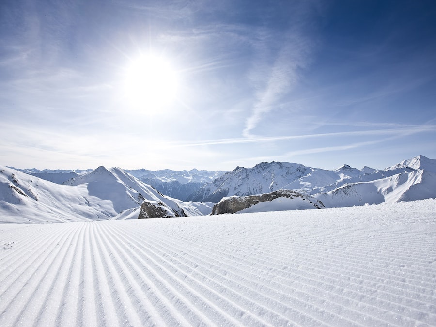 A snowy mountain landscape with a clear sky and distant peaks.