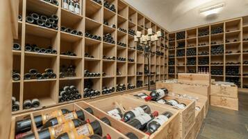 Una bodega con estantes y cajas de madera llenas de botellas de vino.