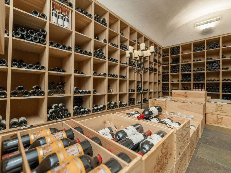 Una bodega con estantes y cajas de madera llenas de botellas de vino.