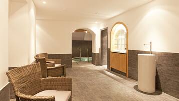Relax in a serene spa area with a hot tub, wicker chairs, and a sleek sink.