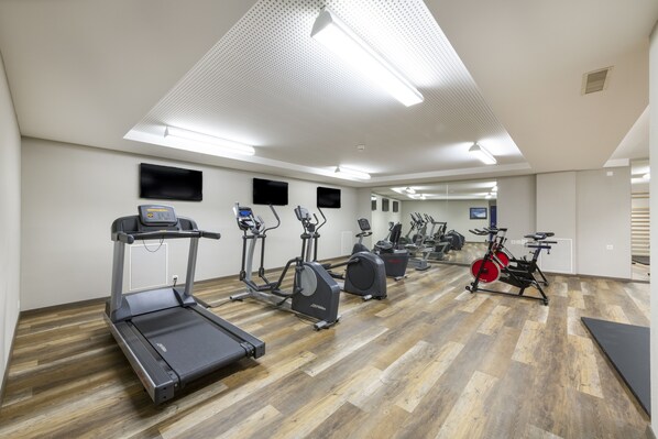 A gym with treadmills, elliptical machines, and stationary bikes. - Edelweiss Swiss Quality Hotel (Sils im Engadin-Segl)