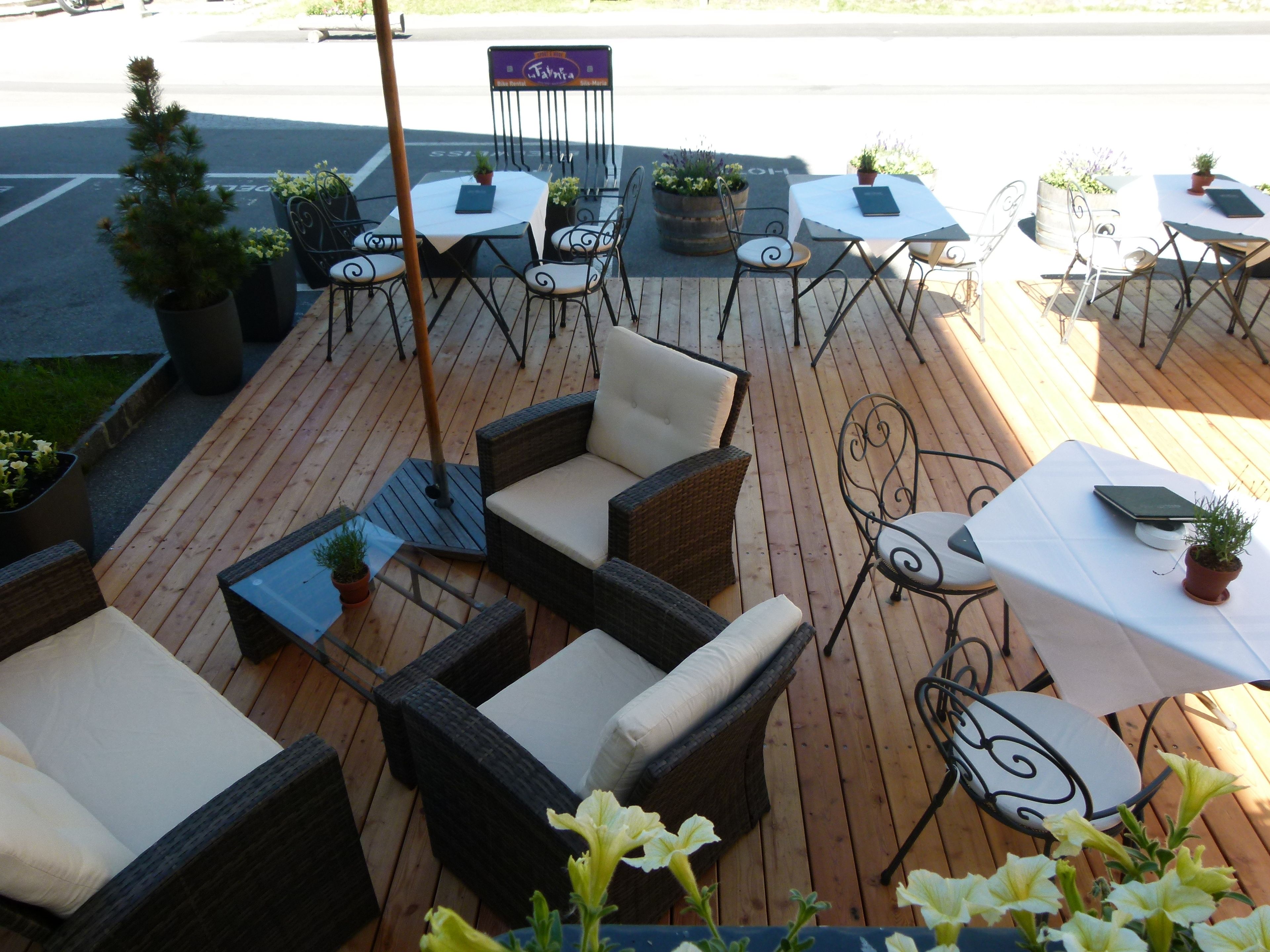 Un espacio al aire libre con mobiliario de mimbre y plantas en macetas.
