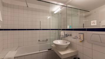 Ein modernes Badezimmer mit Badewanne, Waschbecken und einer Duschkabine aus Glas.