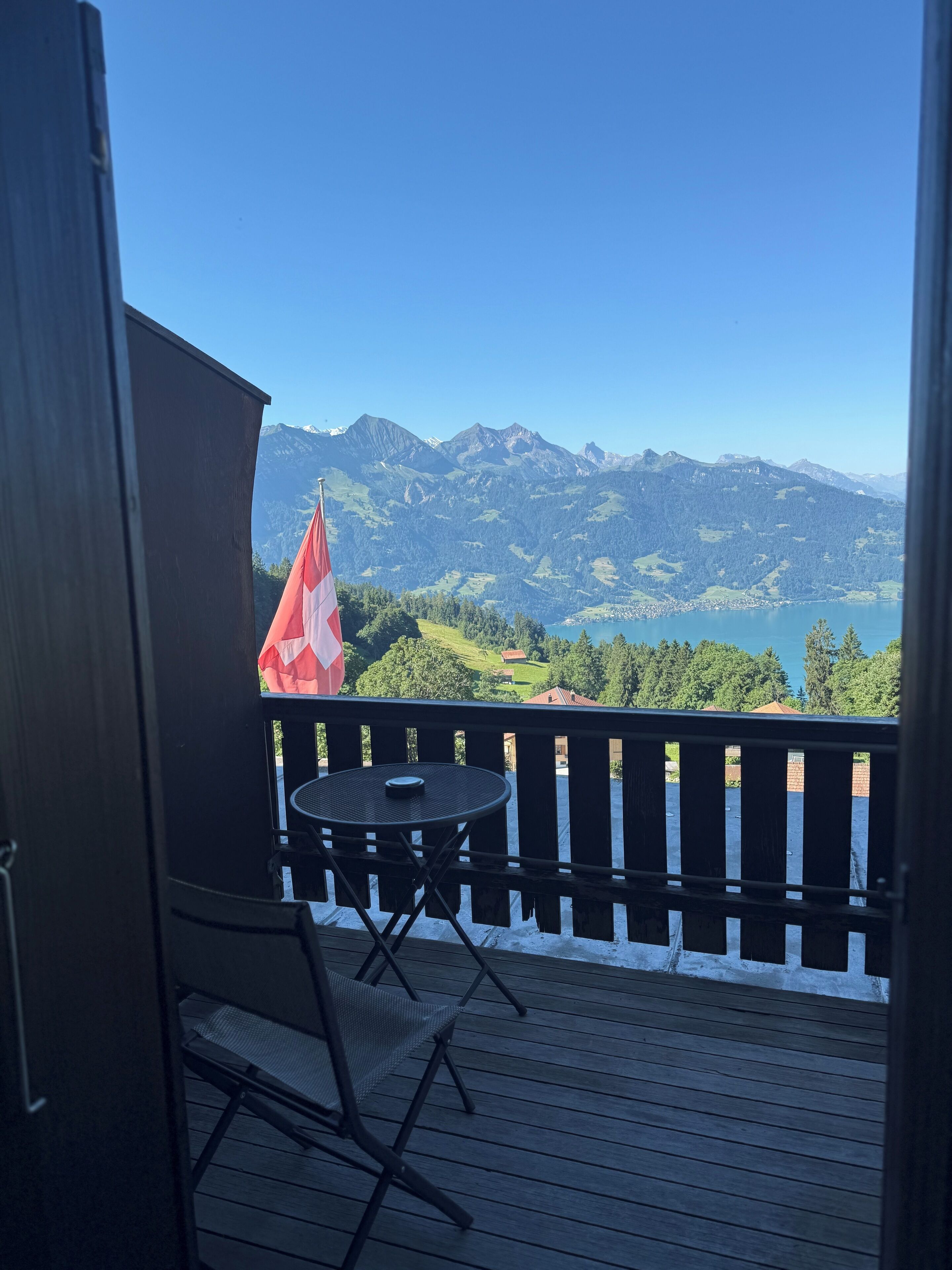 A balcony with a view of mountains and a lake.