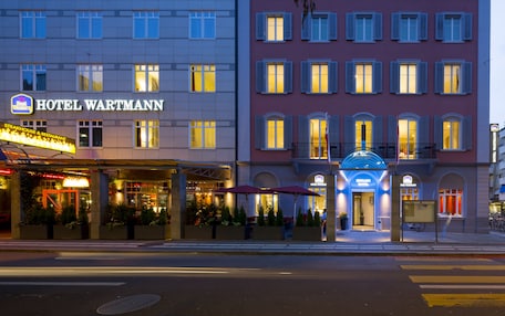 A hotel with a prominent entrance, a visible restaurant, and outdoor seating.