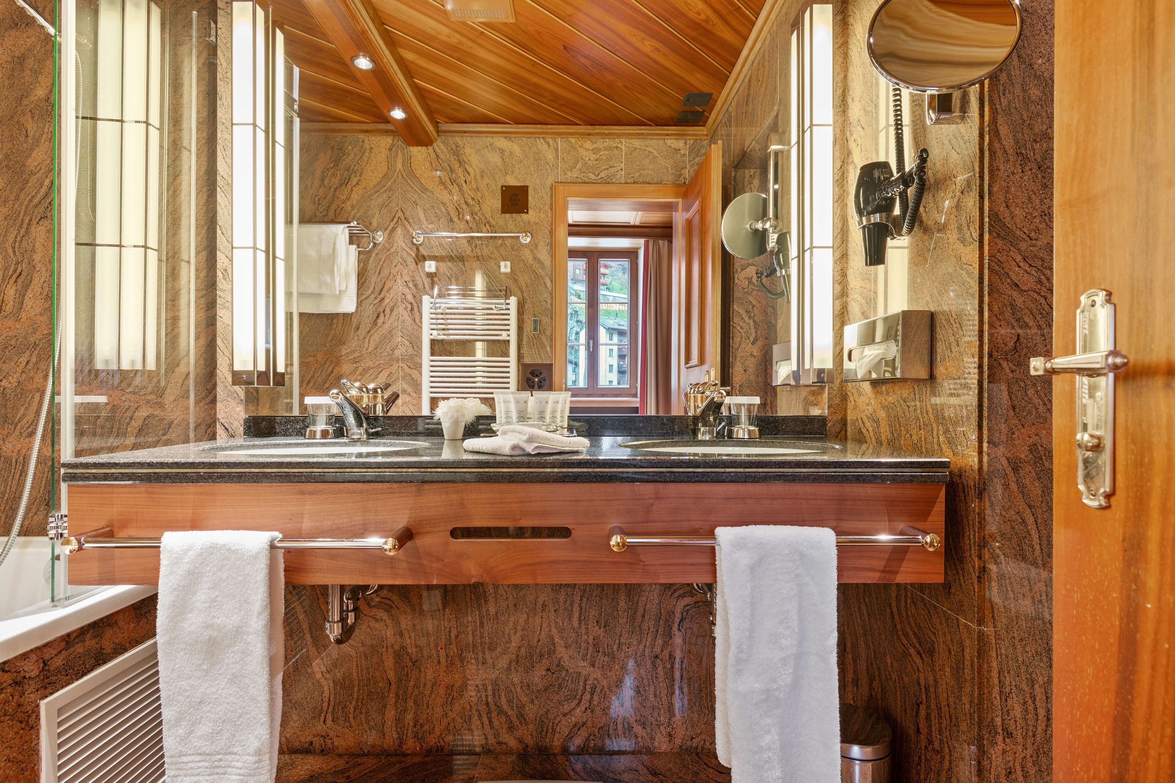 suite, 1 bedroom, corner (matterhorn view) | bathroom | combined shower/bathtub, designer toiletries, hair dryer, bathrobes