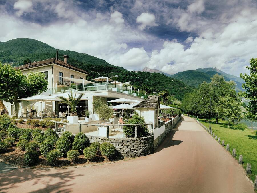 A two-story building with outdoor seating and a stone wall.