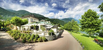 Un hotel moderno con zona de patio, rodeado de exuberante vegetación y montañas.