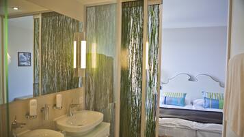 A bathroom with two sinks, a mirror, and a shower curtain with a vertical pattern.