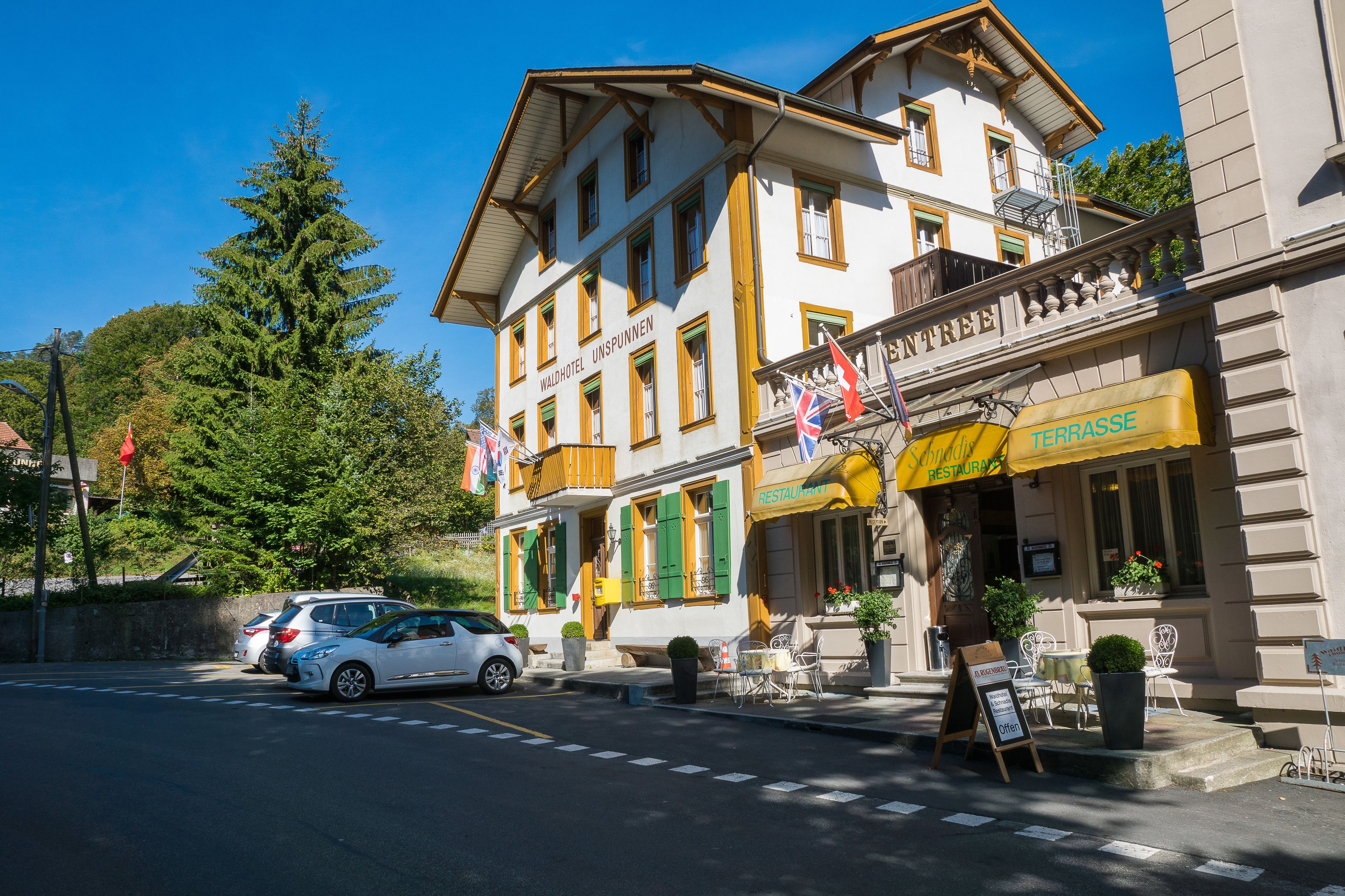 Ein Hotel mit Terrasse und Sitzgelegenheiten im Freien.