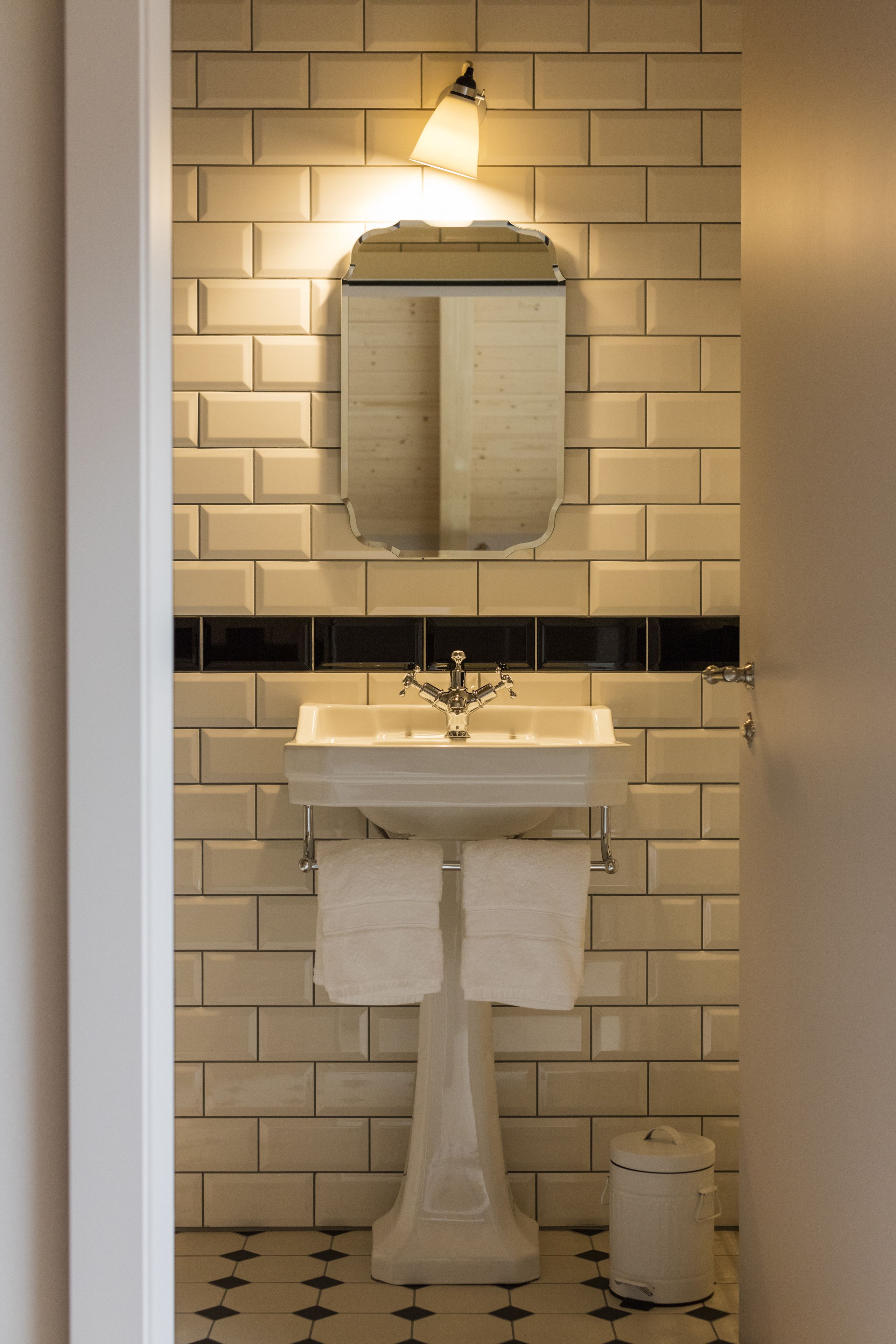 Un baño con un lavamanos blanco, un espejo y un inodoro.