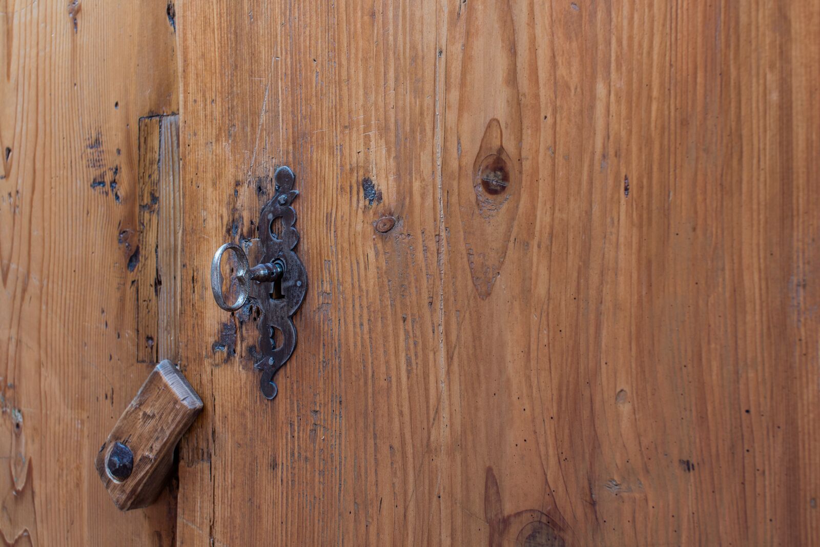 Una puerta de madera con un cerrojo metálico y una cerradura.