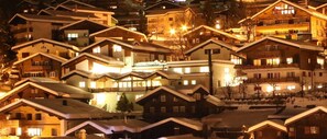 A cluster of chalet-style buildings with steep roofs, likely part of a ski resort. - Paradis (Leukerbad)