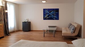 A modern living room with a sofa, a small table, and a cabinet. - Zum Spalenbrunnen (Basel)