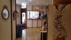 A reception area with a reception desk, a mirror, and a trash bin. - Zum Spalenbrunnen (Basel)