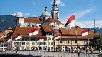 A historic building with a prominent tower and multiple flags, suggesting a significant location.