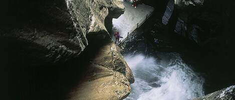 A rocky cave entrance with a waterfall.