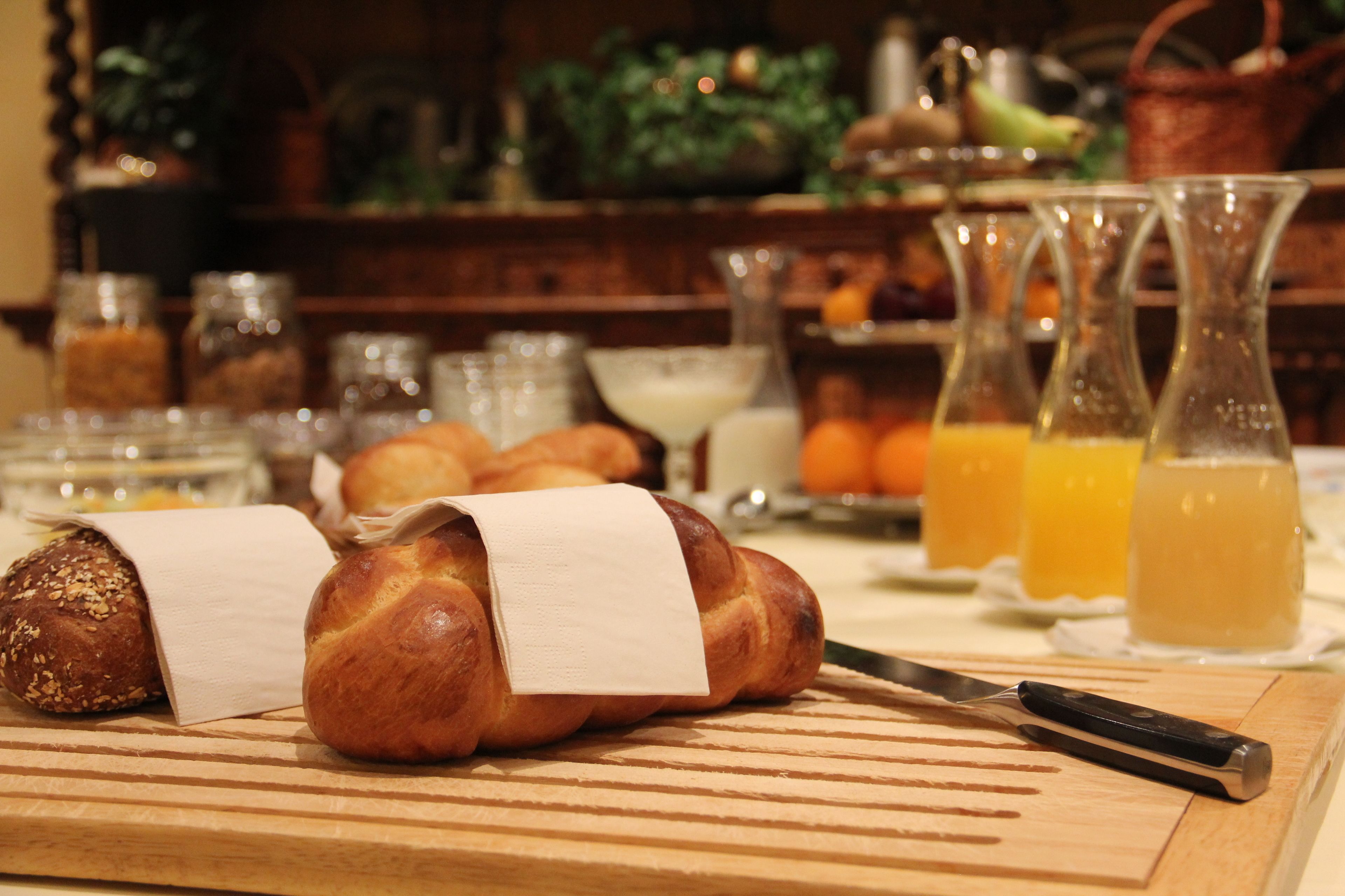 A wooden cutting board with bread and a knife.