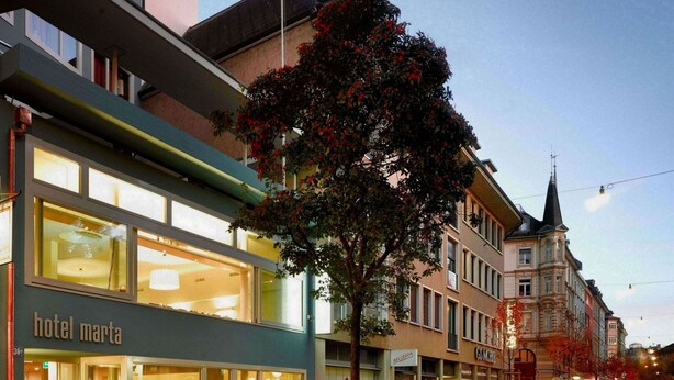A hotel named 'hotel marta' with a modern facade, large windows, and a tree in front. - Hotel Marta - 1950’s architecture in Zurich’s vibrant old town, near main station (Zürich)