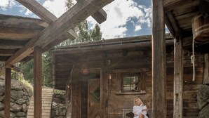 Une cabane rustique en bois, avec un escalier en pierre menant à une porte en bois.