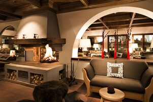 Una sala de estar acogedora con chimenea de piedra, un sofá y una mesita.