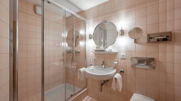Une salle de bain moderne avec une douche à parois de verre, un lavabo et des toilettes.