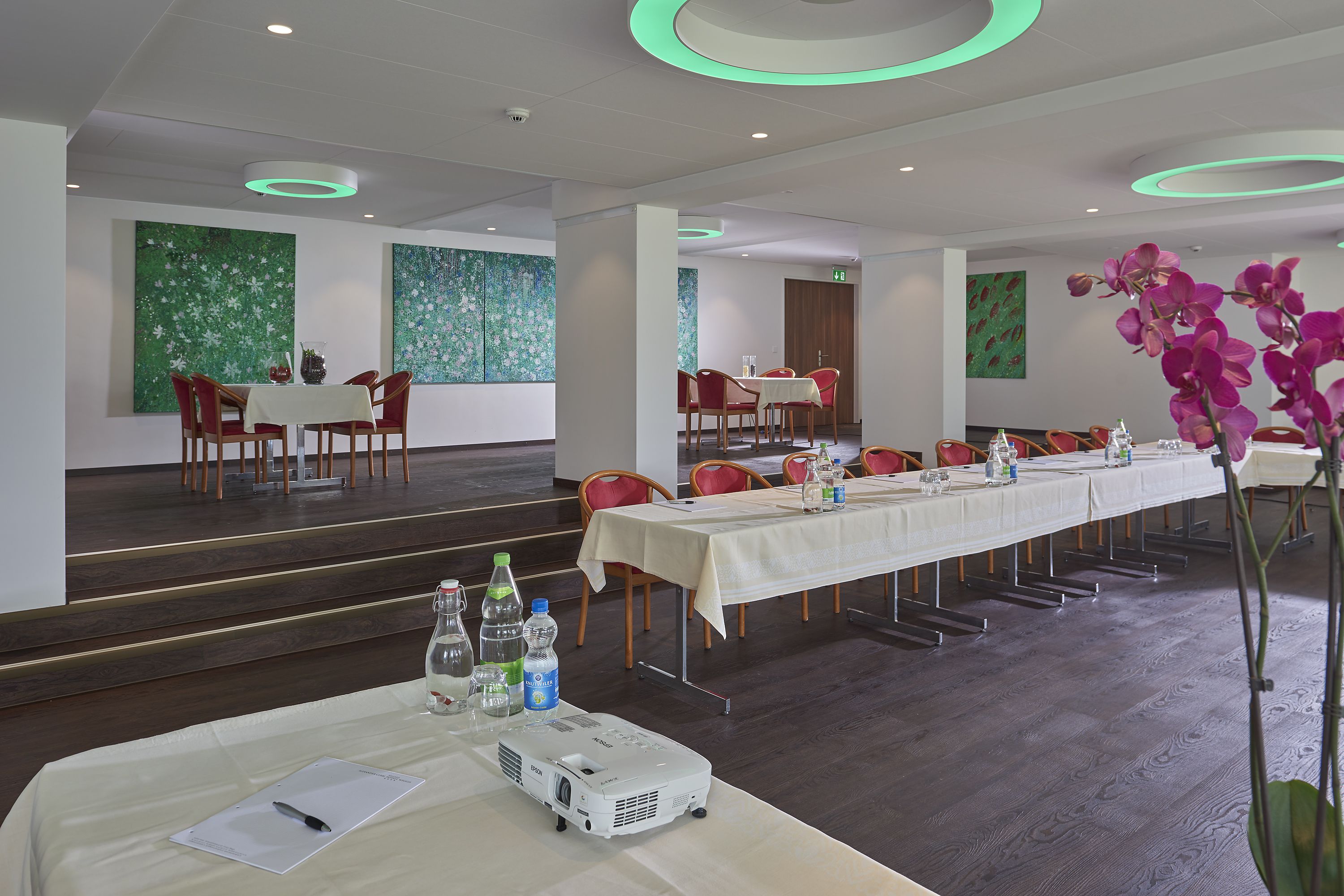 A conference room with a long table, chairs, a projector, and a whiteboard.