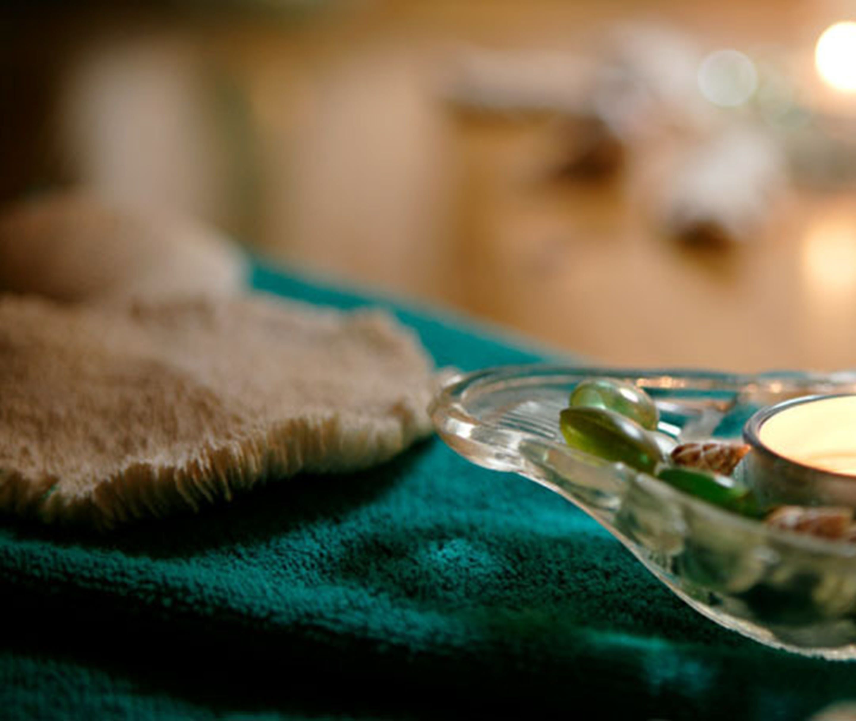 Un gros plan d’un récipient en verre contenant des objets verts, posé sur un tissu de couleur turquoise, qui pourrait faire partie de la décoration d’une pièce.