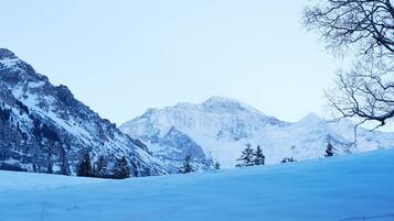 Un paisaje montañoso cubierto de nieve con cielo despejado.