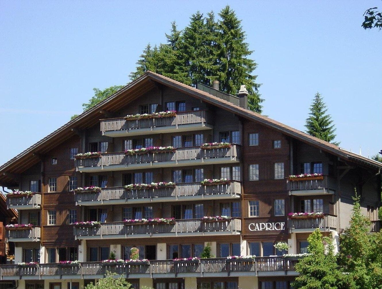 Et hotel med flere etager, med blomsterpyntede balkoner, et tydeligt 