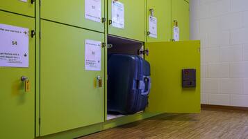 A set of green lockers with numbered tags, each with instructions for use.