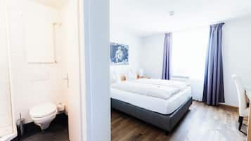 Een moderne hotelkamer met een bed, een badkamer en uitzicht op de stad.