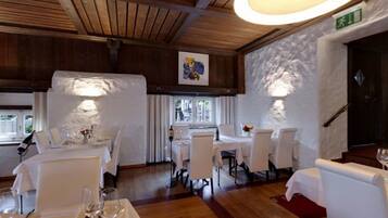 Un restaurante con techos de madera y mesas blancas.