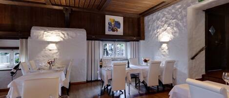 A restaurant with wooden ceilings and white tables.