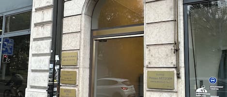 A hotel entrance with a sign reading "HOTEL ENTRÉE" and a number "2" above it.